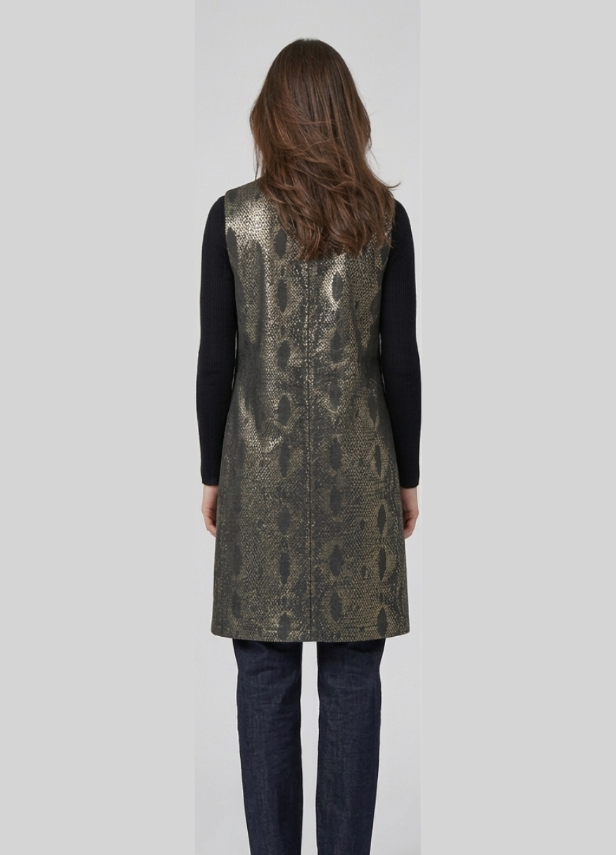 Person wearing a metallic sequin vest over a black long-sleeve shirt on a white background