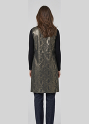 Person wearing a metallic sequin vest over a black long-sleeve shirt on a white background