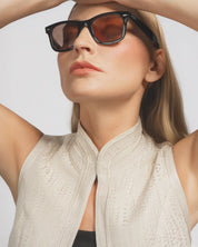 Woman wearing sunglasses with a neutral background