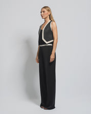 Woman wearing a black and white evening gown against a plain background