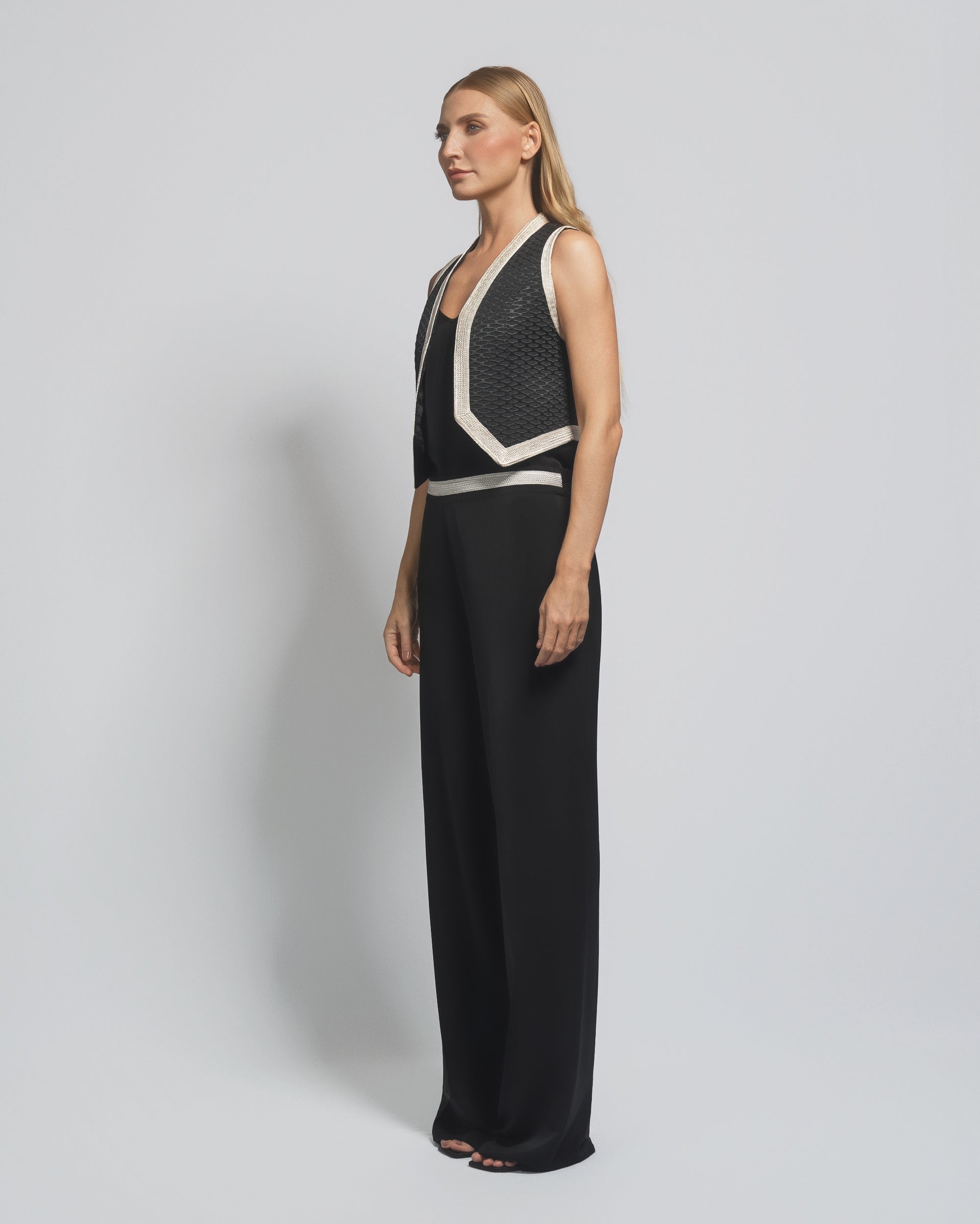 Woman wearing a black and white evening gown against a plain background