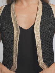 Black swimsuit with beige trim on a plain background