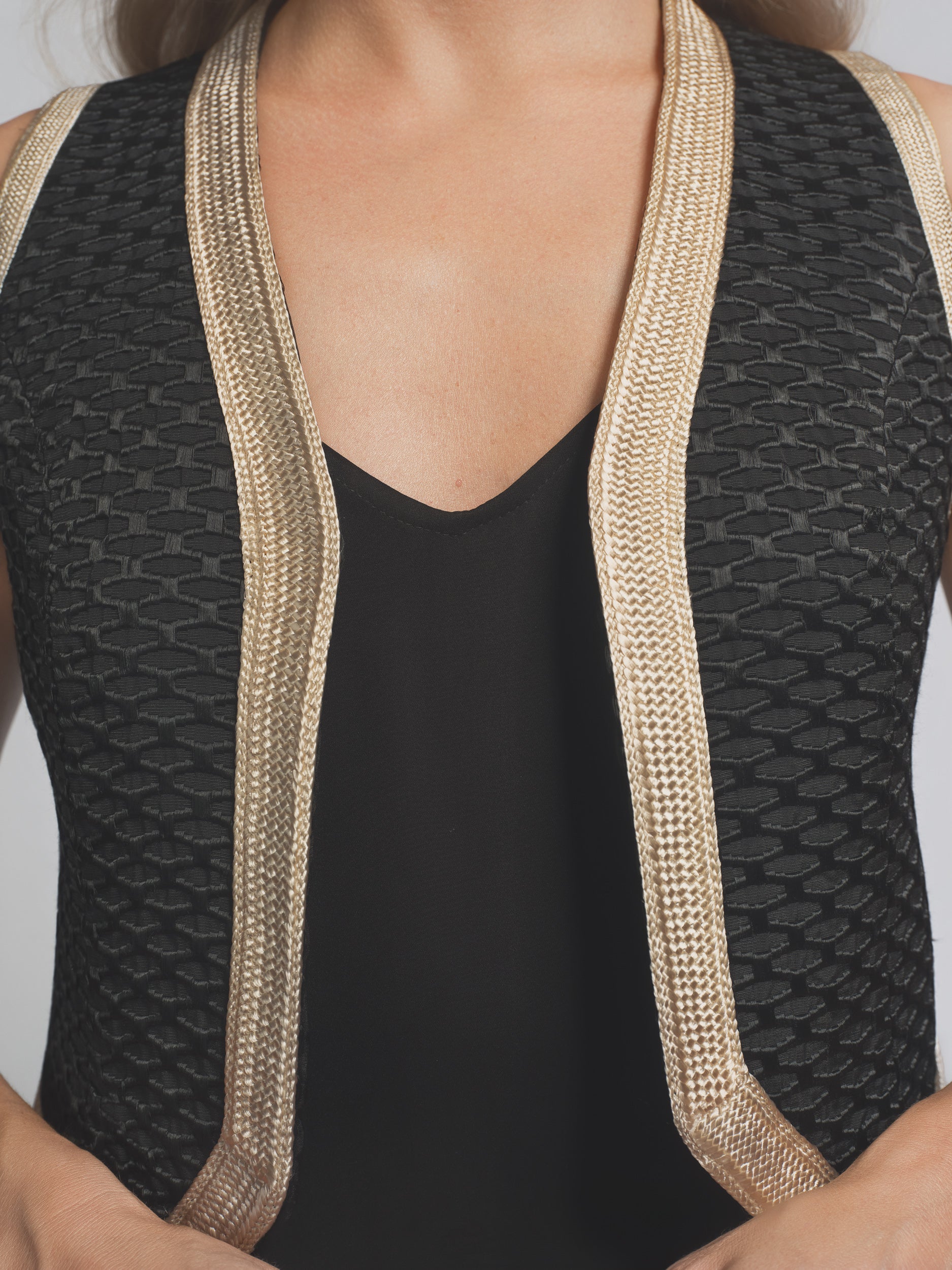 Black swimsuit with beige trim on a plain background