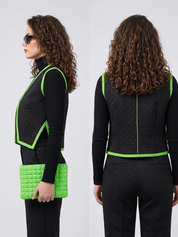 A side-by-side composite image showing the profile and back views of a model wearing a subtly textured black vest and trousers outfit, accented with bright neon green braided trim and paired with a matching green quilted clutch.